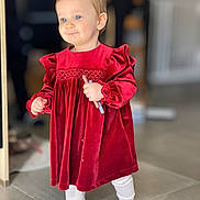 Romy a rejoint le concours — aidez-le/la à gagner de superbes lots ! toddler, child, red_dress, velvet, barefoot, indoor, floor_tiles, holding_object, cute, portrait, young_child, standing, long_sleeves, white_leggings, blonde_hair, blue_eyes, soft_lighting, home_interior, smiling, small_person