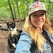 Cortado joined the competition — help win amazing prizes! woman, cat, outdoor, forest, backpack, denim_jacket, cap, smile, nature, pet, animal, happy, walking, leaf, tree, adventure, exploring, daylight, casual, portrait