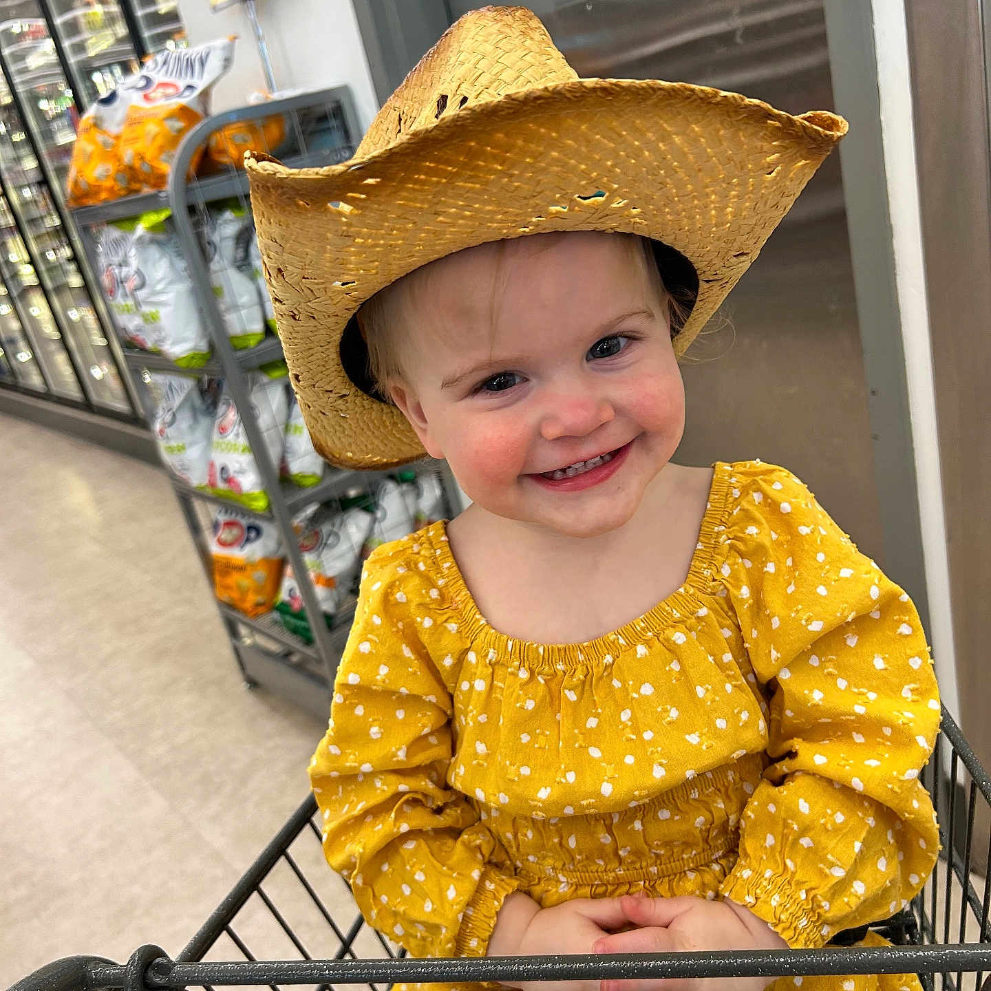 Evelynn is registered to the contest to win money with this photo: baby, basket, cap, clothing, costume, cowboyhat, face, happy, hat, head, indoors, person, photography, portrait, shelf, shop, shopping, shoppingcart, smile, sunhat