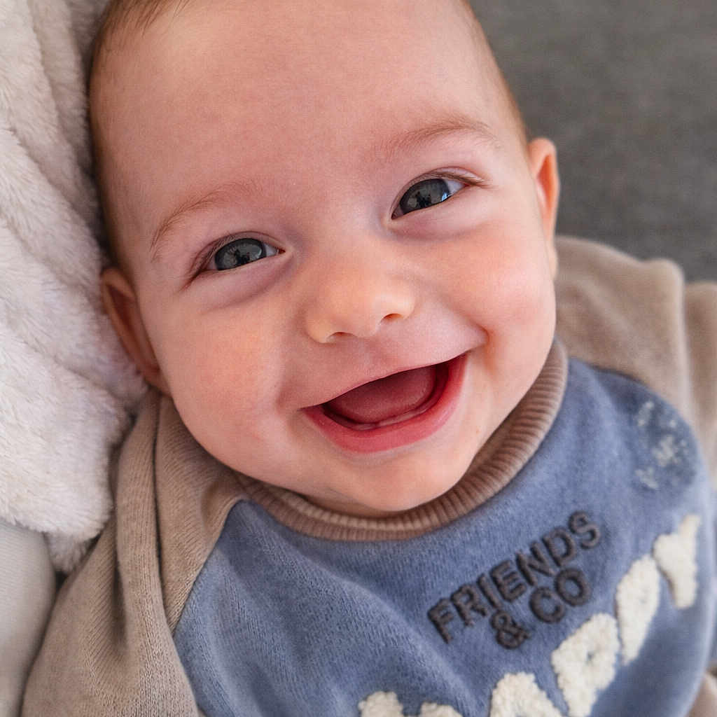 Timéo participe au concours pour gagner de l'argent avec cette photo : baby, smile, happy, blue_sweatshirt, face, infant, clothing, blanket, portrait, cute, child, young, warm, cozy, indoor, baby_hair, close_up, expression, person, soft_texture