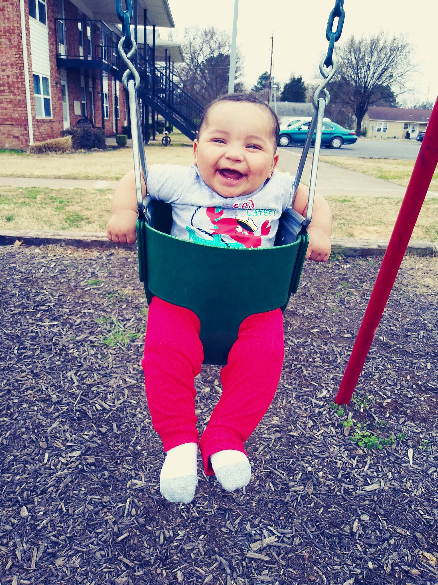 Tavaris joined the competition — help win amazing prizes! baby, child, city, facial_expression, fun, happy, human_settlement, joy, outdoor_play_equipment, person, play, playground, public_space, recreation, sky, smile, swing, toddler, tree