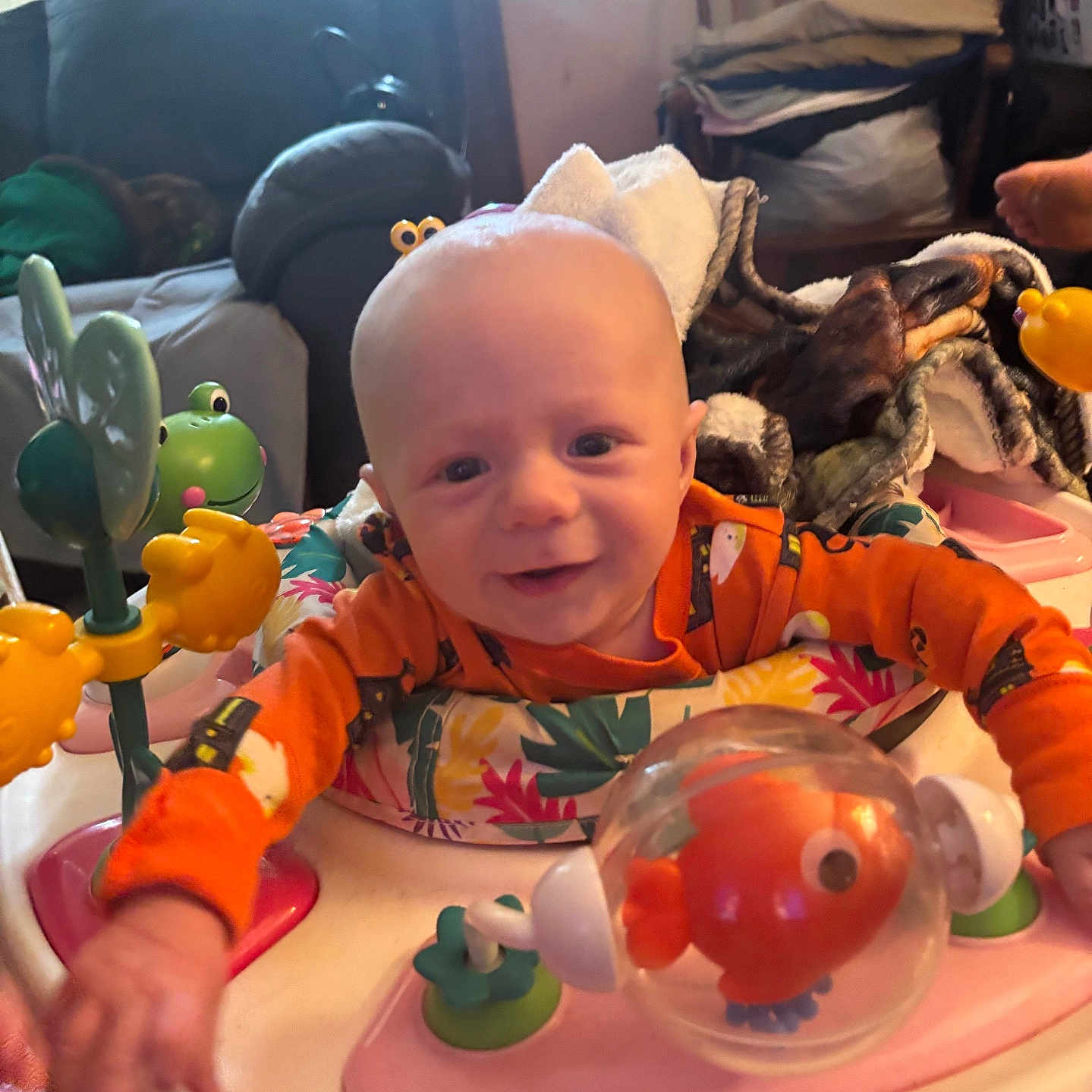 Daxton joined the competition — help win amazing prizes! activity_center, baby, blanket, child, colorful, couch, face, fish_toy, frog_toy, furniture, happy, head, indoor, infant, living_room, orange_clothing, person, playtime, smiling, toy