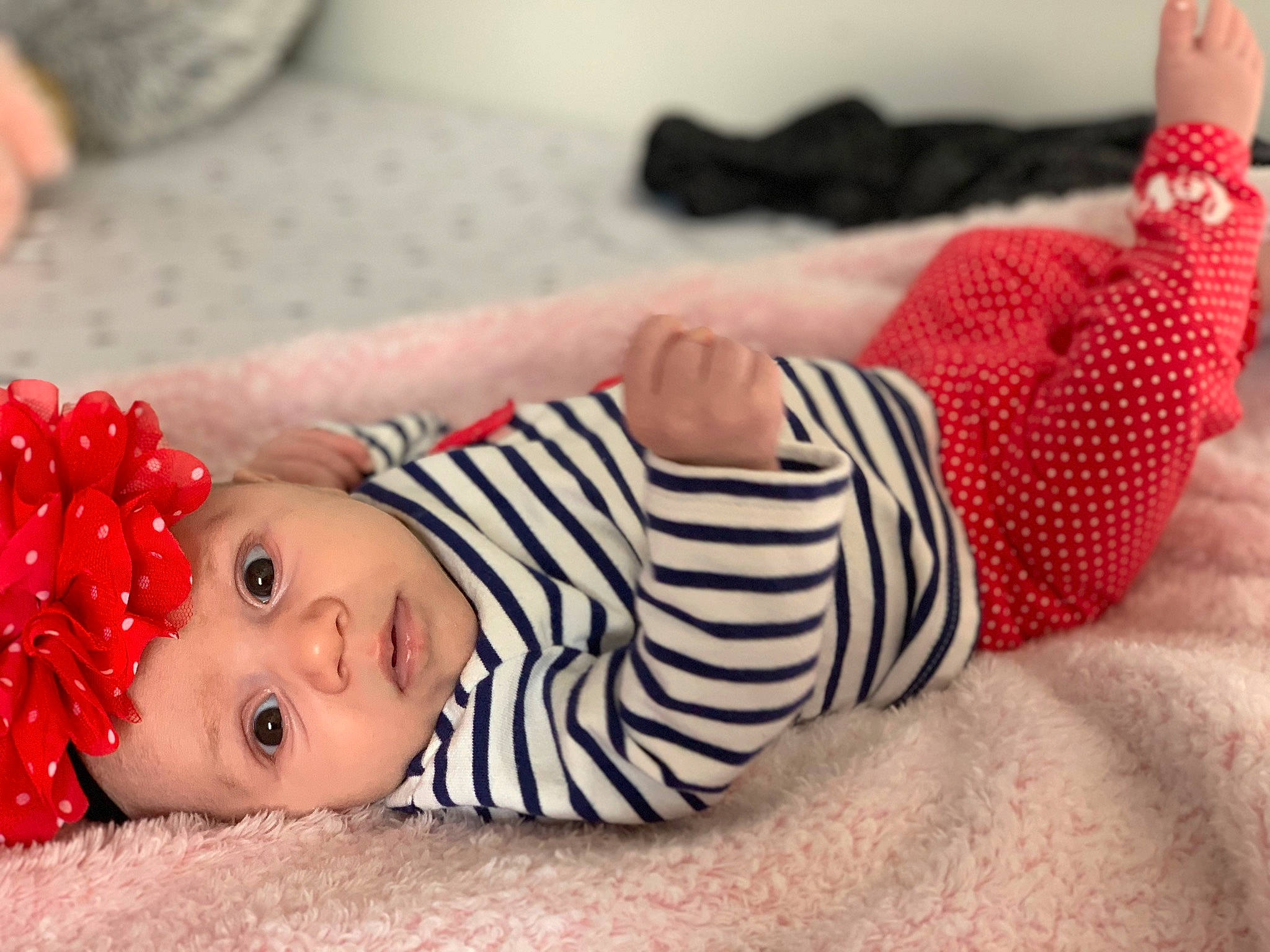 Mylah is registered to the contest to win money with this photo: arm, baby, baby_toddler_clothing, child, comfort, dress, finger, flooring, happy, head, headwear, human_body, joint, knee, person, pink, red, skin, sleeve, thigh