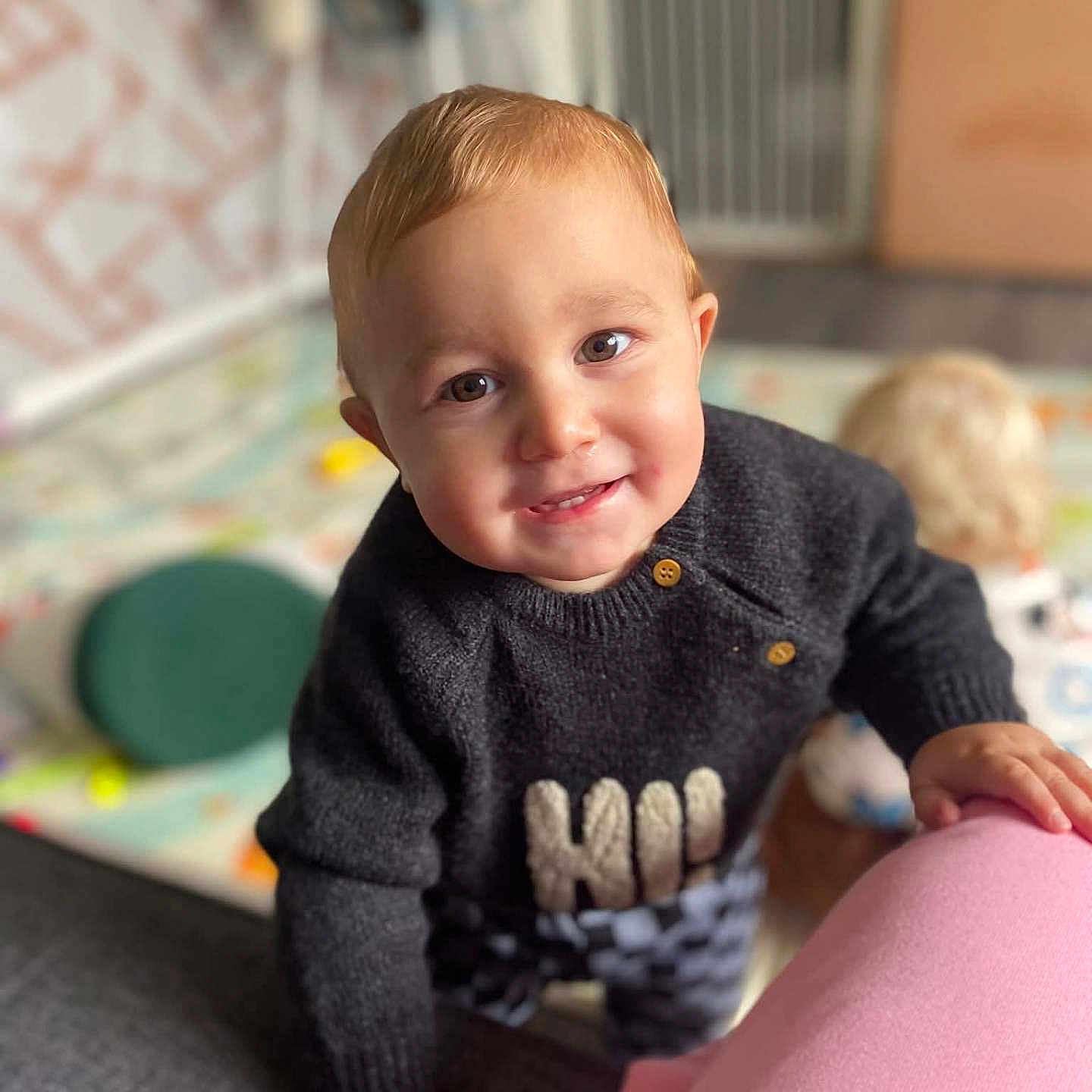 Hunter-James joined the competition — help win amazing prizes! baby_gate, background_blur, candid, checkered_pants, child, cozy, curiosity, expression, face, floor, hand, home, indoor, person, play, smile, sweater, toddler, toy, young_child