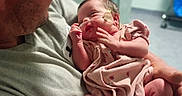 Maggie is registered to the contest to win money with this photo: newborn, infant, baby, child, adult, man, father, parent, holding, hospital, medical, bandage, tube, blanket, pink_clothing, portrait, indoor, family, caregiving, smiling