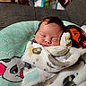 newborn, baby, sleeping, infant, portrait, face, indoors, blanket, swaddled, cushion, sofa, textile, cozy, peaceful, resting, nursery, cartoon, fabric, close_up, photography