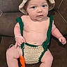 baby, child, infant, portrait, sitting, couch, crocheted_outfit, crocheted_hat, handmade, green, orange, beige, yarn, costume, fashion, blue_eyes, indoor, furniture, full_body, cute
