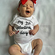 Hadleigh is registered to the contest to win money with this photo: baby, infant, child, onesie, red_bow, headband, valentines_day_text, smile, happy, lying_down, white_background, chubby_legs, bare_feet, small_hands, portrait, newborn, cute, clothing, celebration, studio_photo