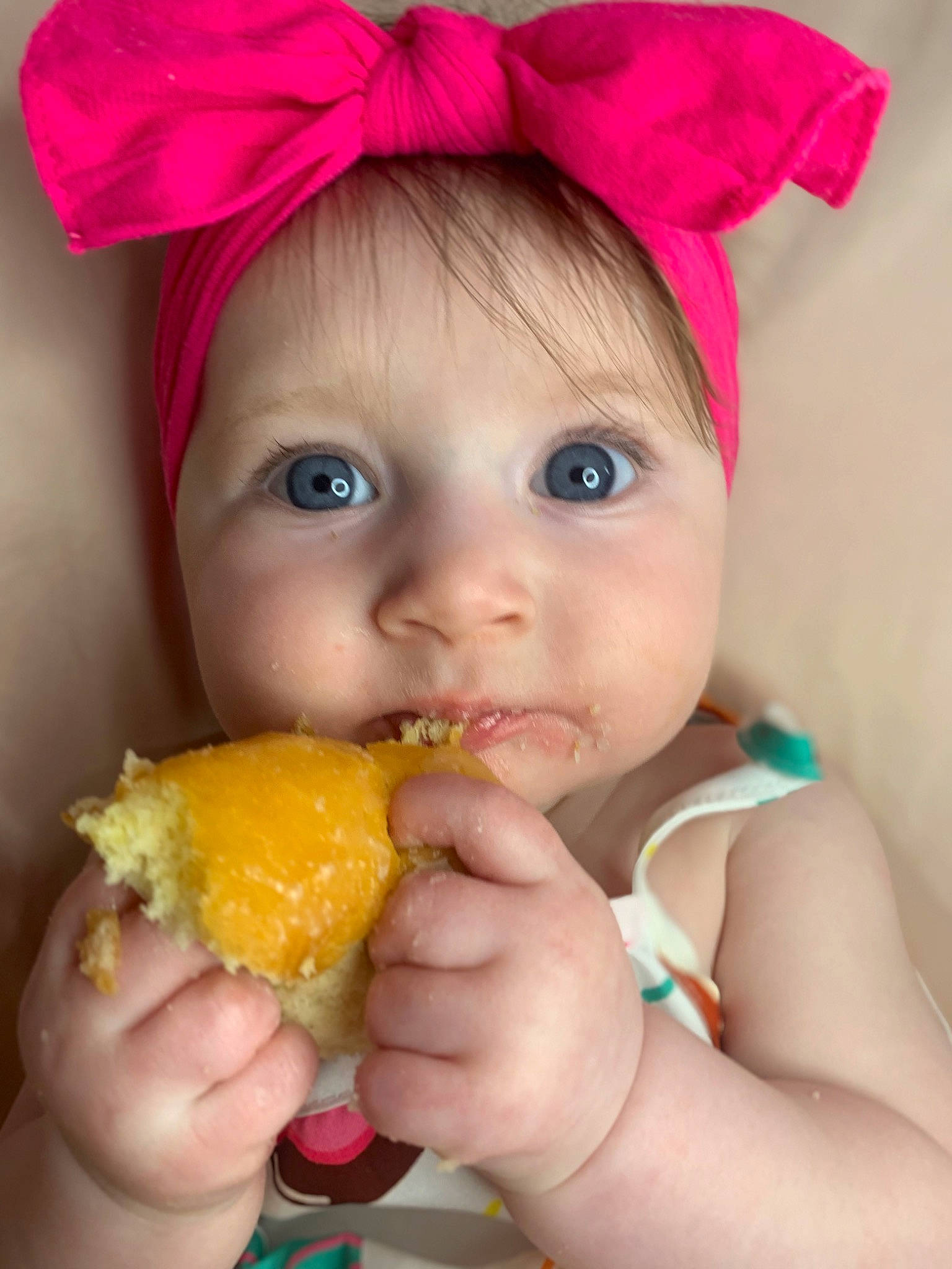 Everleigh is registered to the contest to win money with this photo: biting, child, dress, eyelash, face, finger, food, food_craving, fruit, hand, happy, headwear, lip, mouth, natural_foods, nose, orange, person, plant, skin