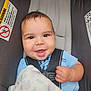 baby, car_seat, smile, child, infant, blanket, blue_clothing, seatbelt, happy, face, cute, young_child, safety, indoors, head, person, portrait, skin, hand, comfort