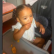 Legacy joined the competition — help win amazing prizes! child, toddler, highchair, eating, snack, tortilla_chips, crumbs, hand, face, braided_hair, pigtails, white_dress, tray_table, indoor, door, doorknob, wood_floor, furniture, brand_logo, portrait