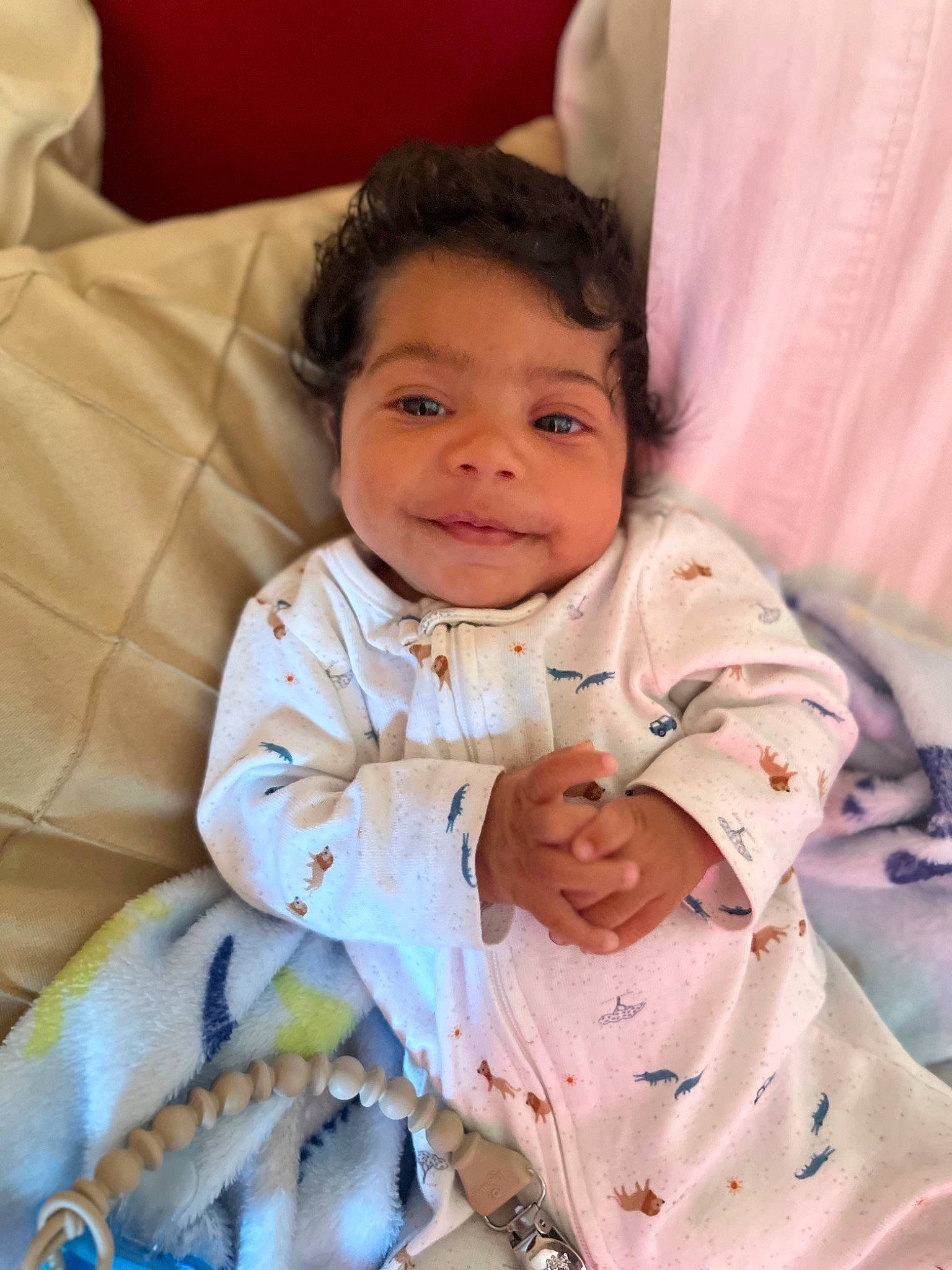 Tahj is registered to the contest to win money with this photo: baby, baby_toddler_clothing, bedding, cheek, child, comfort, eye, finger, fun, gesture, happy, linens, nose, person, room, sitting, skin, sleeve, smile, textile