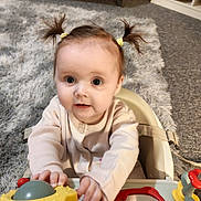Sydney is registered to the contest to win money with this photo: baby, child, pigtails, toy, high_chair, indoor, carpet, curious, infant, play, person, furniture, mirror, cute, hands, clothing, smiling, face, home, young