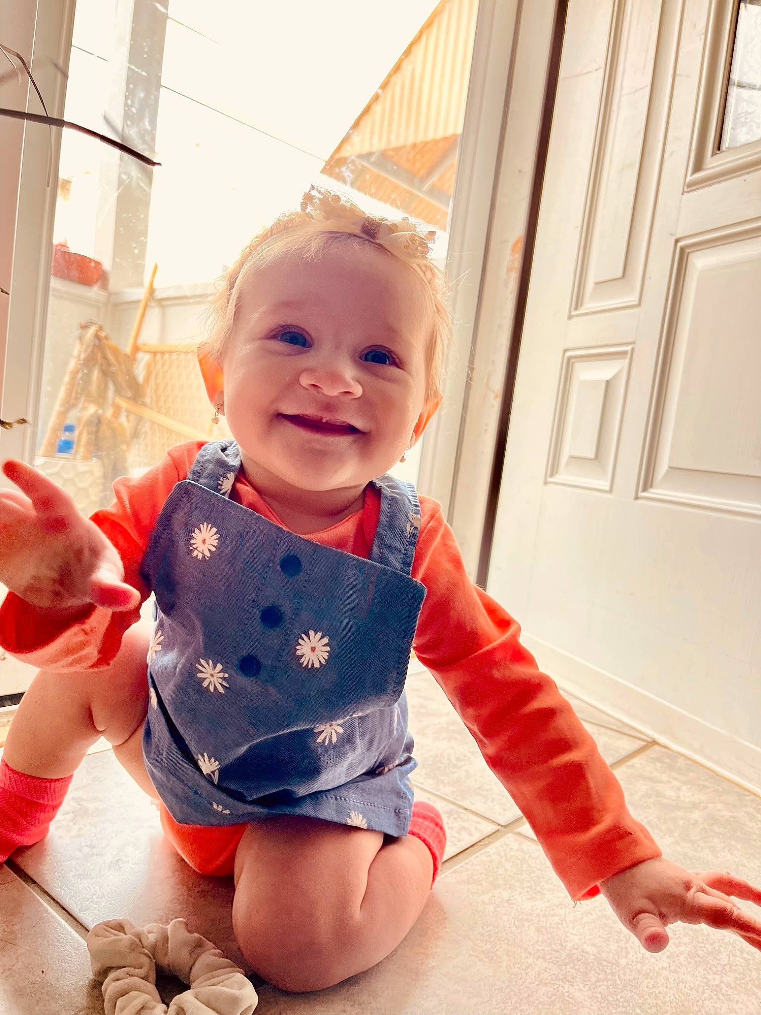 Giavanna is registered to the contest to win money with this photo: arm, baby, baby_toddler_clothing, eye, facial_expression, floor, flooring, foot, hand, happy, joy, leg, orange, person, pink, skin, sleeve, smile, standing, t_shirt