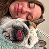 woman, dog, bulldog, tongue_out, close_up, face, pet, snuggle, cozy, indoor, blanket, fur, cute, relaxed, portrait, animal, human, resting, home, sleepy