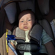 Bryan joined the competition — help win amazing prizes! baby, car_seat, child, infant, seatbelt, clothing, striped, blue, clip, hand, face, serious, shadow, light, straps, safety, closeup, indoors, person, cute