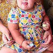 Millie-Jean joined the competition — help win amazing prizes! toddler, child, blonde_hair, curly_hair, tongue_out, colorful_clothing, floral_dress, adult, holding, indoor, family, playful, cute, expression, person, sitting, legs, hands, smile, casual
