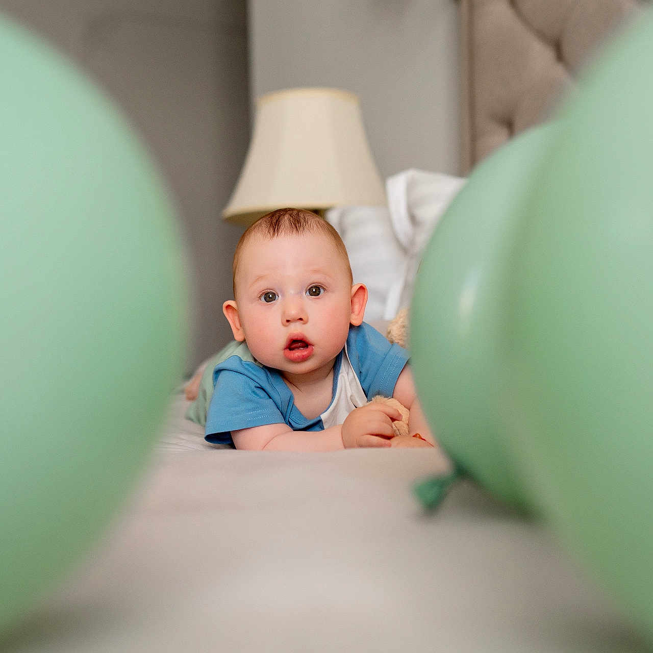 Noah joined the competition — help win amazing prizes! baby, balloons, bed, blanket, blue_shirt, child, curious, expression, face, head, home, indoor, lamp, pillow, portrait, room, soft_lighting, toddler, toy, young_child