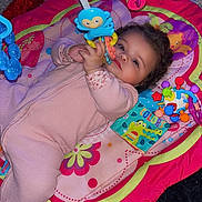 London joined the competition — help win amazing prizes! attention, baby, bright_colors, carpet, child, colorful, curly_hair, cute, floor, indoor, infant, lying_down, monkey_toy, pink_clothing, play_mat, playtime, small_hands, soft_toys, toddler, toy