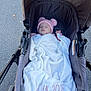 Emiliana is registered to the contest to win money with this photo: baby, stroller, blanket, hat, sleeping, outdoor, pavement, child, cute, cozy, pink, white, soft, pom_poms, newborn, infant, resting, person, transport, casual