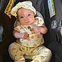 Storibelle is registered to the contest to win money with this photo: baby, infant, child, car_seat, headband, outfit, floral_pattern, foot, hand, face, eyes, warning_label, black, fabric, seatbelt, cute, portrait, sitting, indoors, person