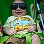 baby, child, sunglasses, stroller, green, tshirt, shorts, smile, happy, outdoor, grass, seatbelt, person, infant, summer, sunny, cute, casual, clothing, portrait