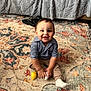 toddler, child, smiling, indoor, carpet, toy, striped_shirt, pants, sock, floor, couch, blanket, happy, person, portrait, baby, cute, playful, home, seated