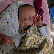 Léïa participe au concours pour gagner de l'argent avec cette photo : baby, sleeping, nasal_tube, blanket, pillow, knitted_toy, octopus, animal_print, infant, cute, bed, resting, child, toddler, soft_lighting, indoors, peaceful, nursery, clothing, healthcare