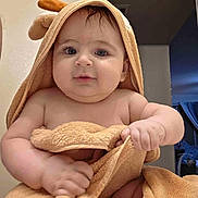 Qais Alhamwi is registered to the contest to win money with this photo: baby, child, towel, hooded_towel, indoors, cute, chubby, grip, skin, face, expression, blue_eyes, soft_texture, blanket, person, newborn, bath_time, curious, infant, portrait