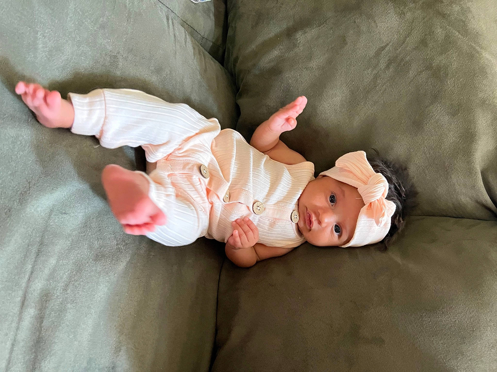 Kaylani is registered to the contest to win money with this photo: arm, baby, baby_products, baby_toddler_clothing, cheek, comfort, doll, fashion_accessory, foot, grass, hand, headwear, leg, linens, peach, person, plant, sitting, skin, sleeve