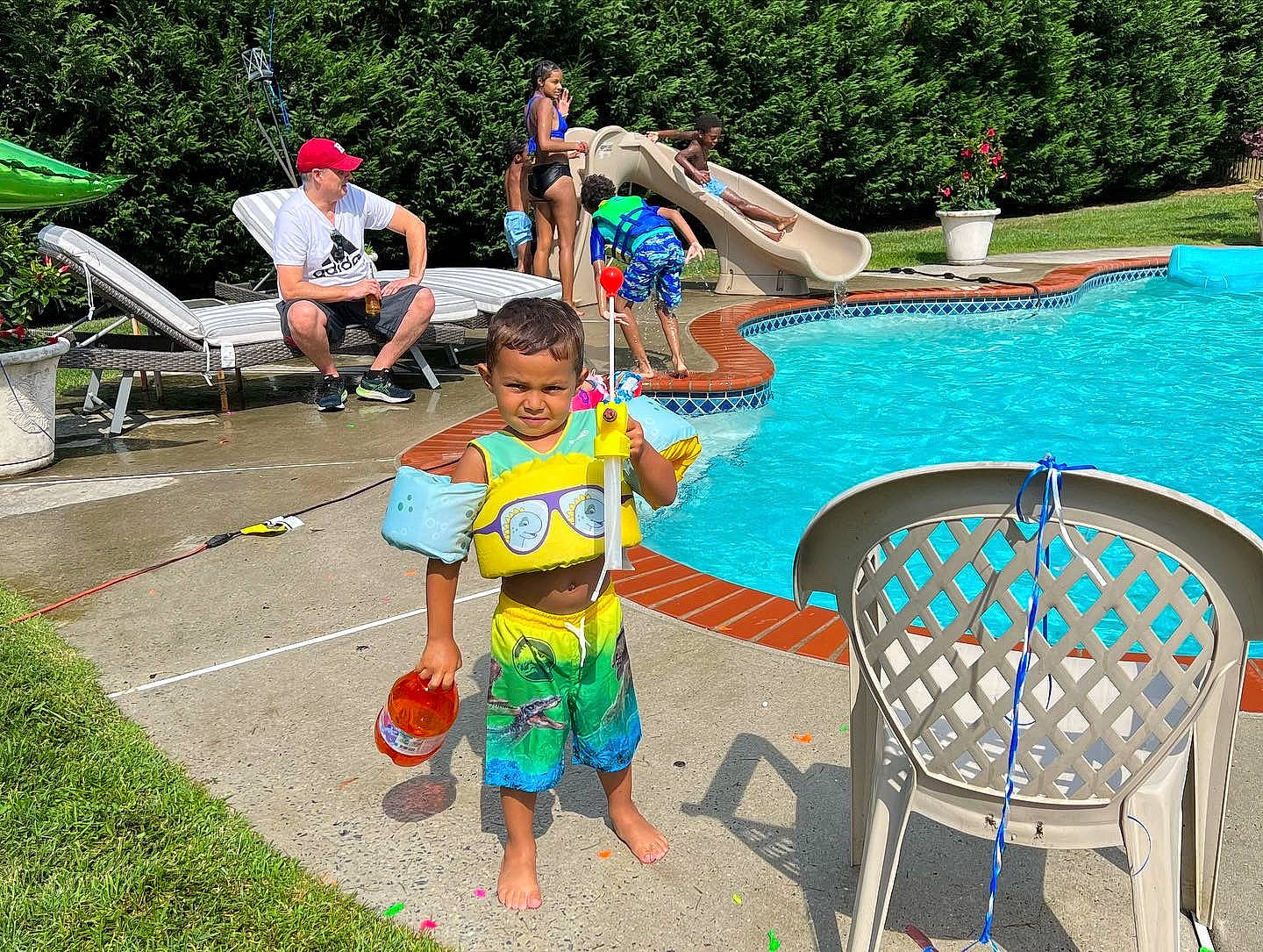 Malakai is registered to the contest to win money with this photo: barechested, barefoot, board_short, chair, event, fun, grass, headwear, leisure, nonbuilding_structure, outdoor_furniture, person, plant, recreation, resort, resort_town, shorts, swimming_pool, swimwear, travel