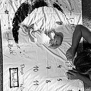 Oilver joined the competition — help win amazing prizes! baby, newborn, infant, child, adult, parent, face, portrait, lying_down, milestone_blanket, rainbow, stars, numbers, photography, black_and_white, indoor, carpet, family, cozy, smiling