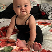 Octavia joined the competition — help win amazing prizes! baby, child, infant, black_clothing, sitting, blanket, floral_pattern, indoor, cute, face, feet, hands, person, young_child, curious, pout, soft_texture, home, cozy, portrait