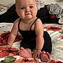baby, black_clothing, blanket, child, cozy, curious, cute, face, feet, floral_pattern, hands, home, indoor, infant, person, portrait, pout, sitting, soft_texture, young_child