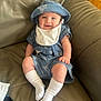 Cody is registered to the contest to win money with this photo: baby, smile, blue_outfit, hat, bib, white_socks, couch, leather, infant, child, sitting, happy, cute, indoors, person, clothing, footwear, portrait, casual, comfort