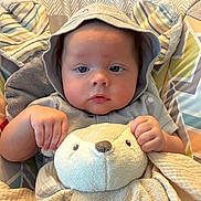 Bryce joined the competition — help win amazing prizes! baby, child, infant, hood, stuffed_animal, toy, couch, blanket, cute, face, hands, patterned_background, soft, cozy, indoor, portrait, expression, person, clothing, comfort