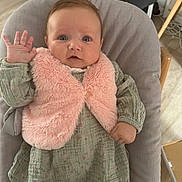 Ava participe au concours pour gagner de l'argent avec cette photo : baby, infant, child, pink_vest, green_dress, waving_hand, blue_eyes, seated, cushion, chair, indoor, wooden_floor, curious_expression, clothing, person, portrait, cute, soft_texture, baby_girl, home