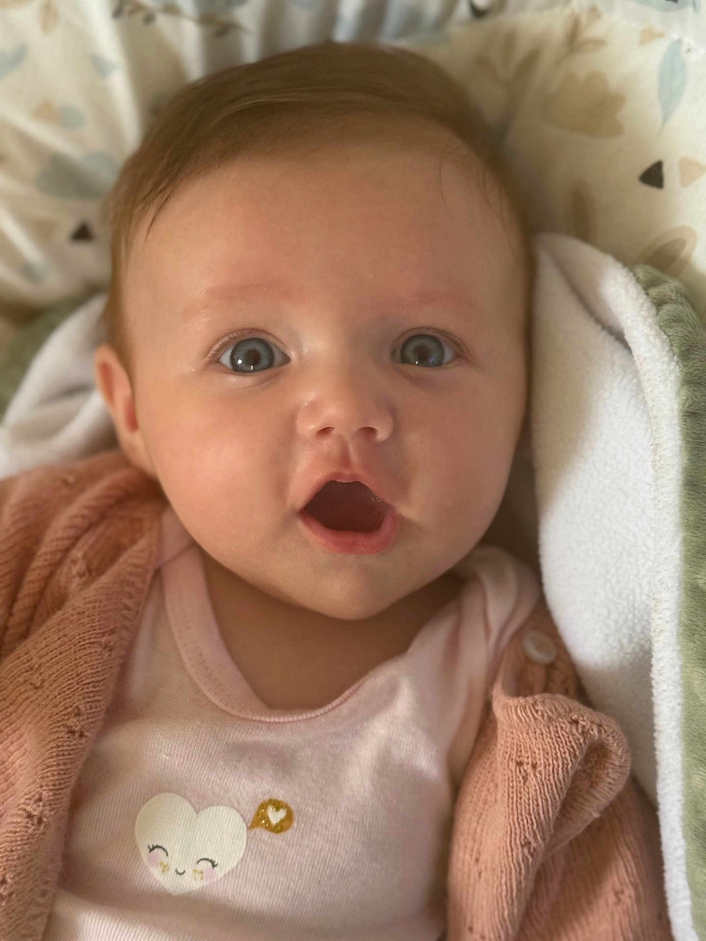 Ava participe au concours pour gagner de l'argent avec cette photo : baby, infant, face, eyes, mouth, clothing, cardigan, pink, blanket, cute, expression, portrait, child, soft, cozy, lying_down, closeup, adorable, smile, heart