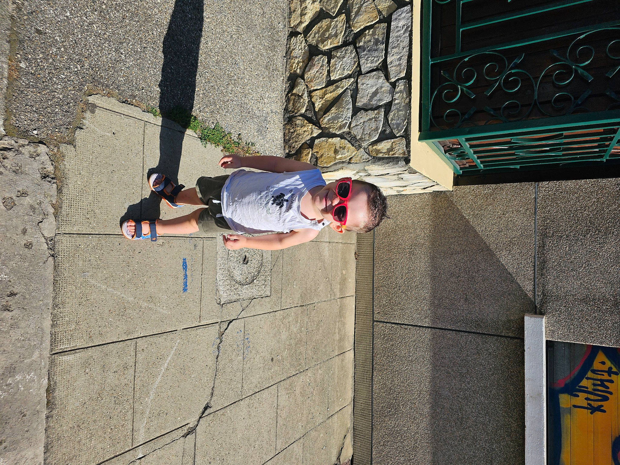 Gabriel participe au concours pour gagner de l'argent avec cette photo : asphalt, brick, brickwork, child, concrete, electric_blue, eyewear, facade, fun, joy, leisure, logo, pedestrian, person, recreation, road_surface, shadow, sidewalk, street, sunglasses