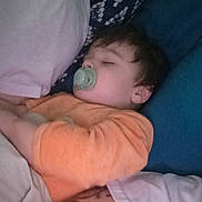 Wayne participe au concours pour gagner de l'argent avec cette photo : child, toddler, sleeping, pacifier, orange_clothing, bed, pillow, blanket, indoor, rest, peaceful, nap, relaxation, person, face, young_child, hair, comfort, cozy, casual