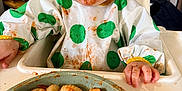 Asher joined the competition — help win amazing prizes! baby, messy, food, gnocchi, high_chair, bib, polka_dots, blue_eyes, face, hands, table, plate, kitchen, indoor, child, eating, smile, clothing, dining, home