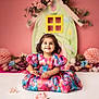 Tiana joined the competition — help win amazing prizes! toddler, child, smiling, dress, floral, colorful, sitting, flower_arrangement, decor, pink_background, portrait, cute, happy, indoor, prop, young_child, hair_bow, playful, bright, innocent