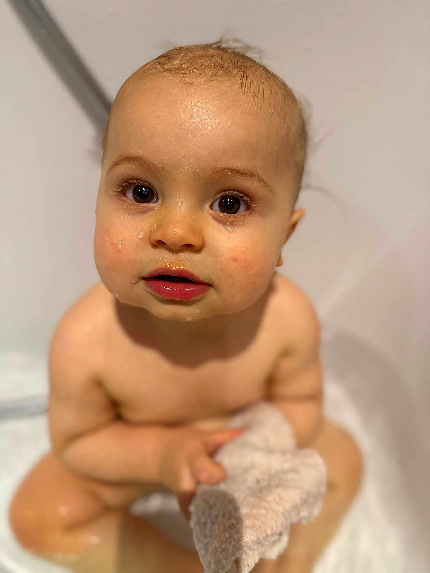 Lyo participe au concours pour gagner de l'argent avec cette photo : baby, child, bath, wet_skin, towel, face, eyes, curious, innocent, water_droplets, skin, hand, sitting, indoors, closeup, portrait, soft_towel, pink_lips, young_child, bathroom
