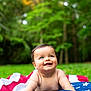 american_flag, baby, background_blur, bare_chest, blanket, blue_eyes, child, cute, daylight, grass, greenery, happy, infant, nature, outdoor, park, portrait, smiling, summer, toddler