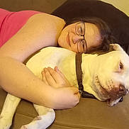 Bella joined the competition — help win amazing prizes! affection, animal, brown_collar, casual_clothing, closeup, comfort, couch, dog, face, friendship, glasses, home, hugging, indoor, person, pet, relaxation, resting, smile, white_dog