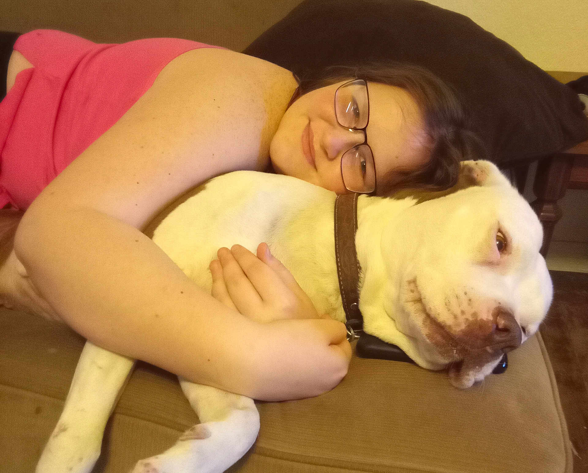 Bella joined the competition — help win amazing prizes! affection, animal, brown_collar, casual_clothing, closeup, comfort, couch, dog, face, friendship, glasses, home, hugging, indoor, person, pet, relaxation, resting, smile, white_dog