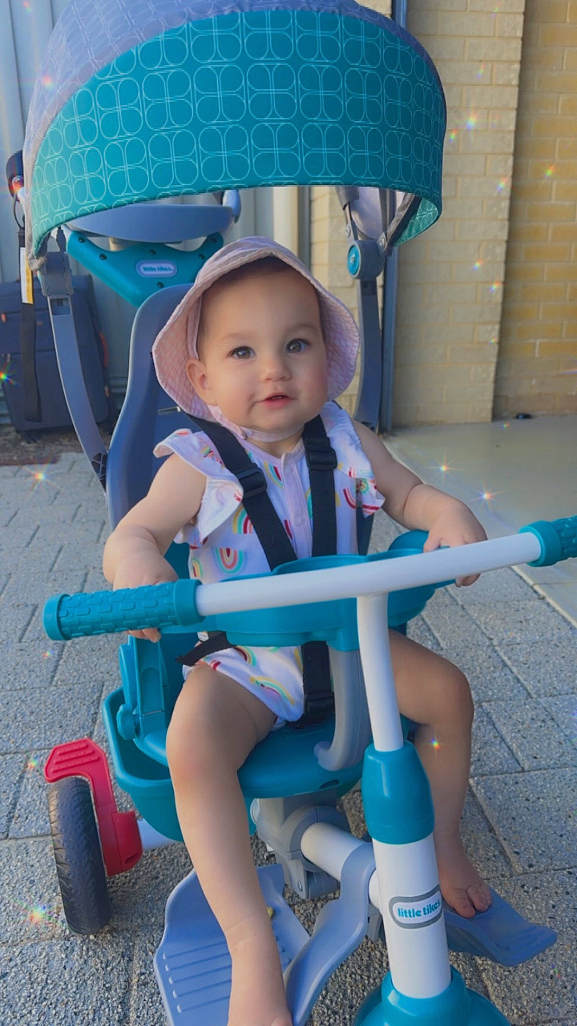 Mackenzie is registered to the contest to win money with this photo: baby, baby_toddler_clothing, blue, child, comfort, electric_blue, fun, happy, human_leg, knee, leg, leisure, person, recreation, sitting, smile, thigh, tire, toddler, wheel