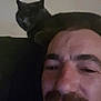 Nénette participe au concours pour gagner de l'argent avec cette photo : animal, casual, cat, couch, dark, face, facial_hair, feline, goatee, home, indoor, man, mustache, person, pet, relaxed, seated, selfie, shadow, smile