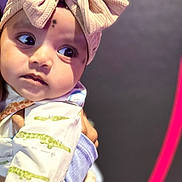 Gowshika joined the competition — help win amazing prizes! baby, child, headband, bow, knitted, curious, face, eyes, clothing, patterned, soft, pastel, portrait, closeup, infant, cute, indoors, hand, gaze, expression