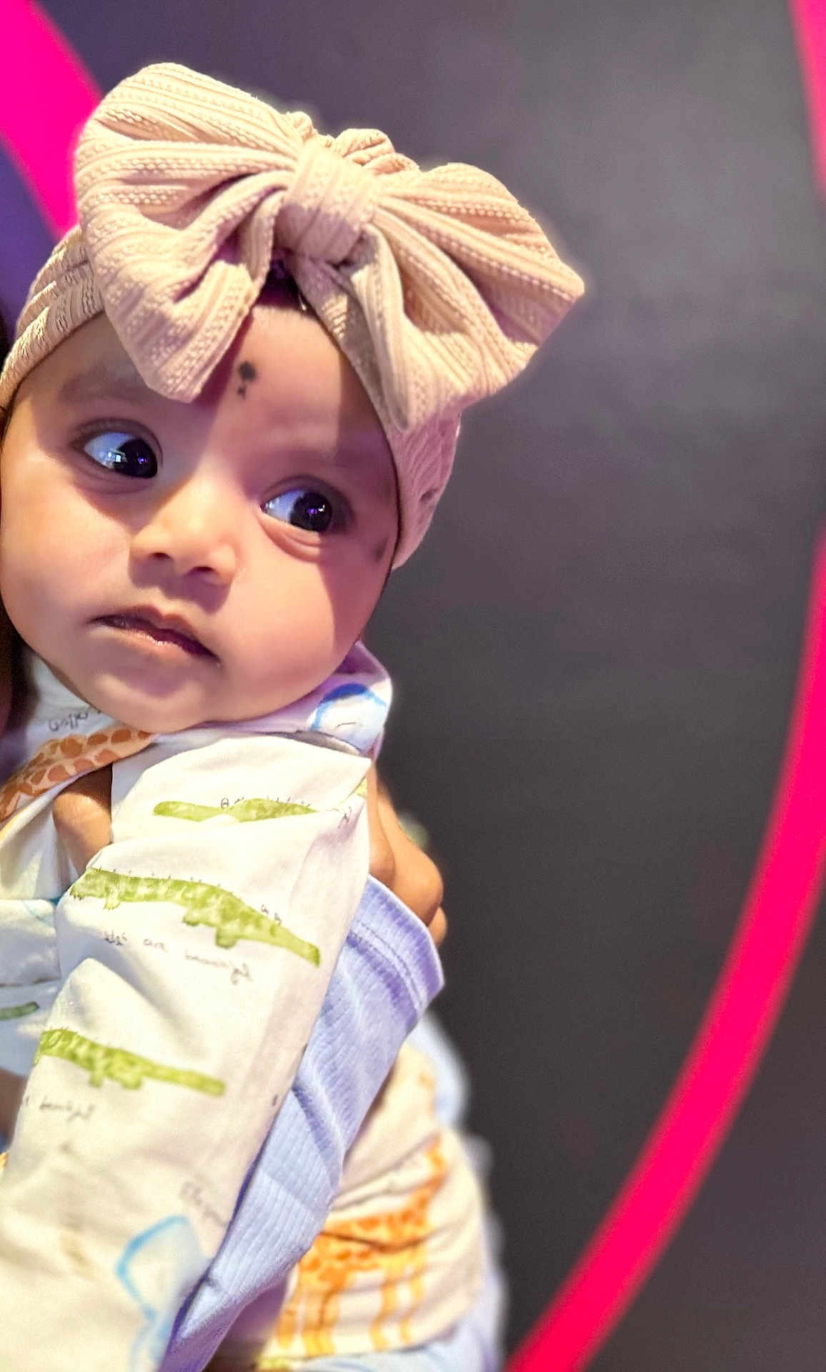 Gowshika joined the competition — help win amazing prizes! baby, child, headband, bow, knitted, curious, face, eyes, clothing, patterned, soft, pastel, portrait, closeup, infant, cute, indoors, hand, gaze, expression